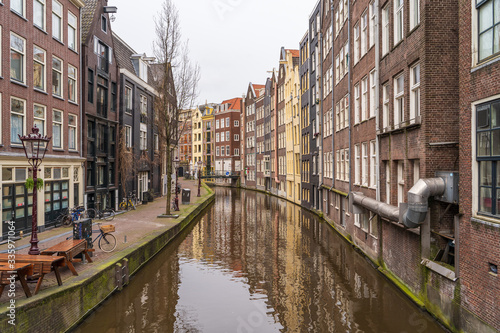 Typical famous water canal and dancing houses in empty Amsterdam downtown without people due to Coronavirus Covid-19, Netherlands. © DedMityay