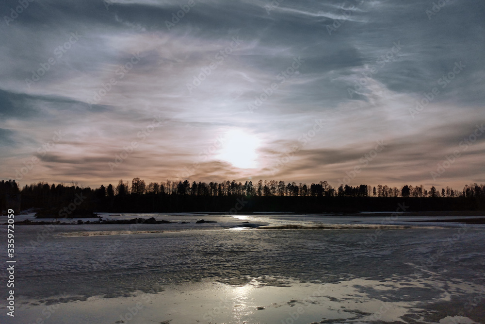 gloomy spring sky over a frozen river
