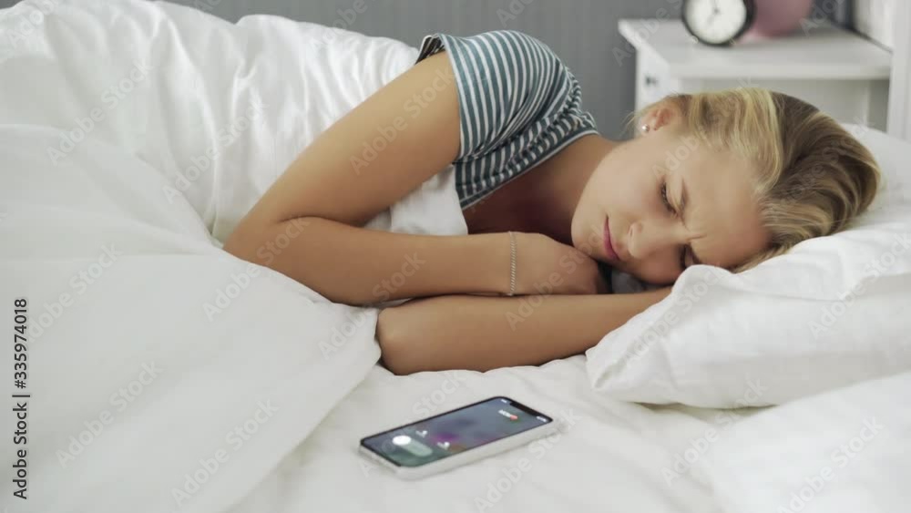 Young beautiful woman waked up by phone call in the morning Young beautiful woman waked up by phone call in the morning