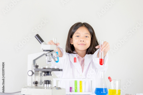 Children science concept, Happy little girl playing doing chemical experiments at the laboratory