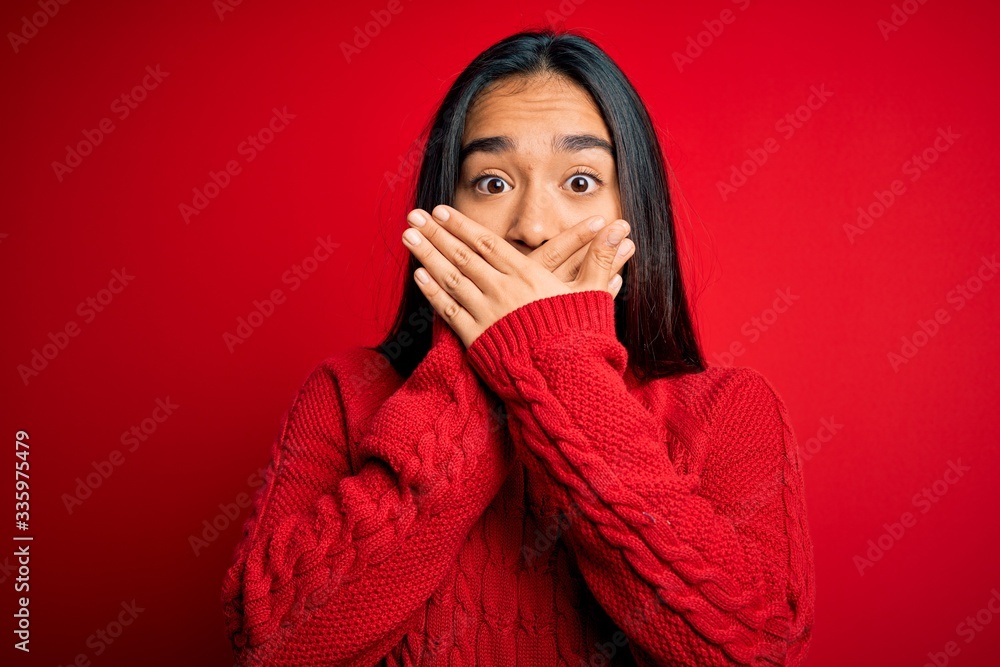 Young beautiful asian woman wearing casual sweater standing over isolated red background shocked covering mouth with hands for mistake. Secret concept. Young beautiful asian woman wearing casual sweater standing over isolated red background shocked covering mouth with hands for mistake. Secret concept.