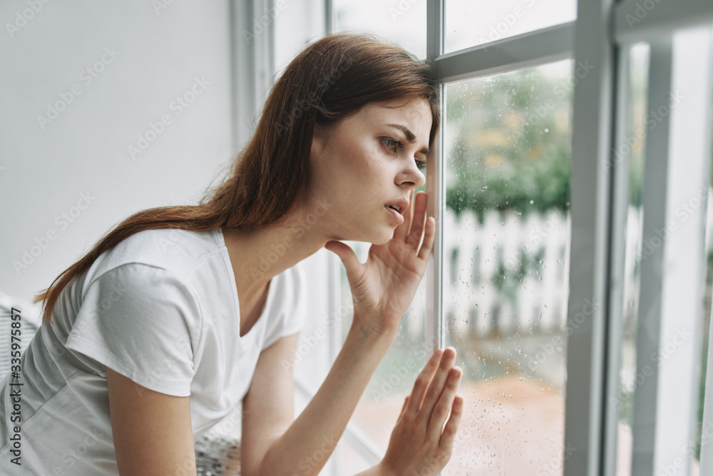 young woman looking out window