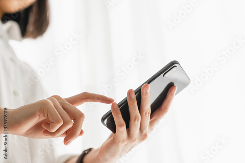 Close-up of hand holding smartphone device and  typing text message on online social.
