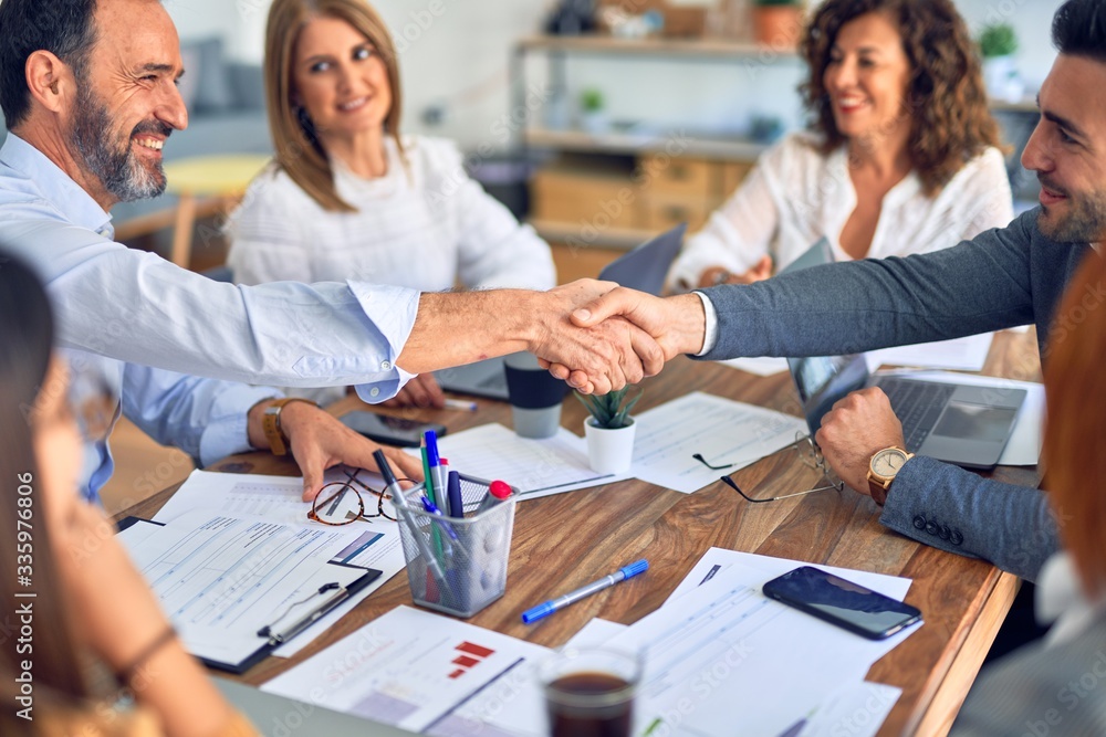 Group of business workers smiling happy and confident. Working together with smile on face shaking hands at the office Group of business workers smiling happy and confident. Working together with smile on face shaking hands at the office