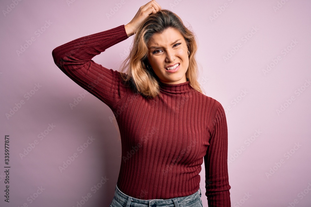 Young beautiful blonde woman wearing casual sweater over isolated pink background confuse and wonder about question. Uncertain with doubt, thinking with hand on head. Pensive concept. Young beautiful blonde woman wearing casual sweater over isolated pink background confuse and wonder about question. Uncertain with doubt, thinking with hand on head. Pensive concept.