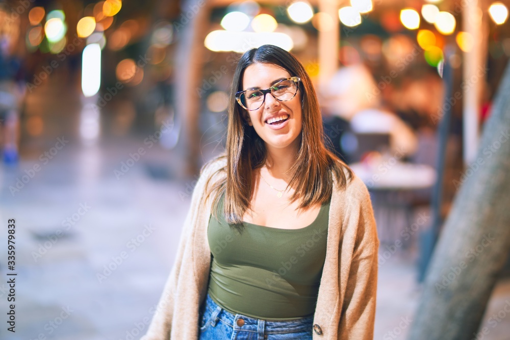 Young beautiful woman smiling happy and confident. Standing with smile on face at the town street Young beautiful woman smiling happy and confident. Standing with smile on face at the town street
