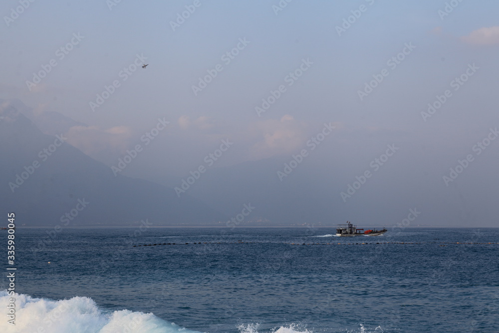 Long exposure sunrise seascape with Chinese fishing junks in the background Long exposure sunrise seascape with Chinese fishing junks in the background