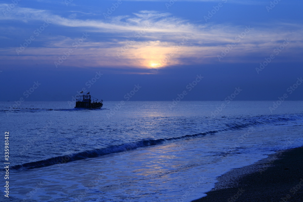 Long exposure sunrise seascape with Chinese fishing junks in the background Long exposure sunrise seascape with Chinese fishing junks in the background