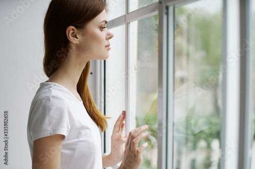 young woman looking out window Free Download young woman looking out window - GFXLoad
