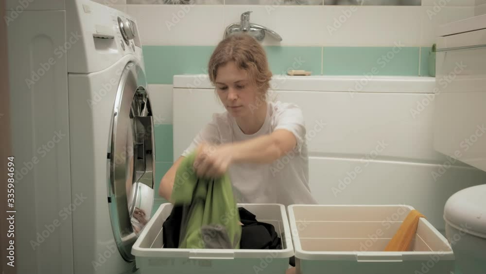 A woman sorts laundry before washing. A woman sorts laundry before washing.