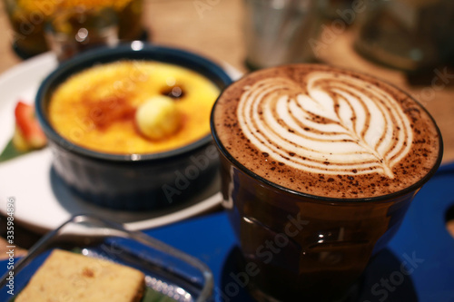 Fotografie Cafe latte with latte art on a cup with Vanilla Crème Brûlée on the background