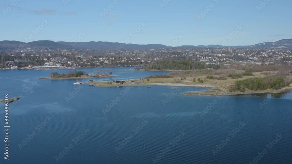 Flying over idyllic seaside Scandinavian coastline with beautiful villas and islands on background during cold sunny spring day Flying over idyllic seaside Scandinavian coastline with beautiful villas and islands on background during cold sunny spring day