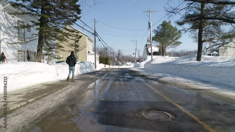 A man walks alone on the street. Filmed during winter in a small Canadian village. A man walks alone on the street. Filmed during winter in a small Canadian village.