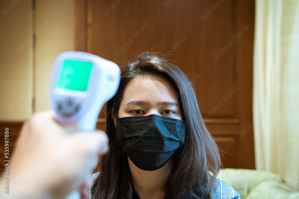 Woman wearing mask protection flu with thermoscan Woman wearing mask protection flu with thermoscan