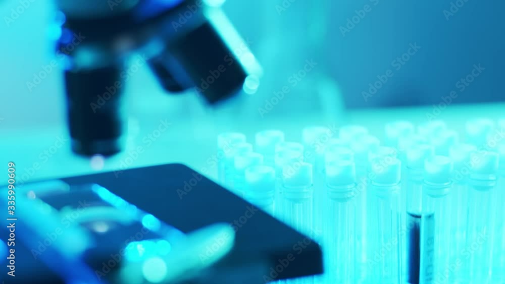 Microscope and a tube with virus. Close-up of scientific laboratory in hospital. Epidemic disease, healthcare, vaccine research and coronavirus 2019-ncov test. Microscope and a tube with virus. Close-up of scientific laboratory in hospital. Epidemic disease, healthcare, vaccine research and coronavirus 2019-ncov test.