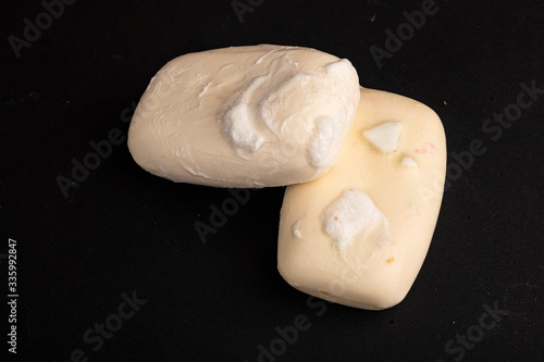 Two pieces of toilet soap on a black background. Frequent hand washing with soap is a prevention of COVID-19 infection. Close up.