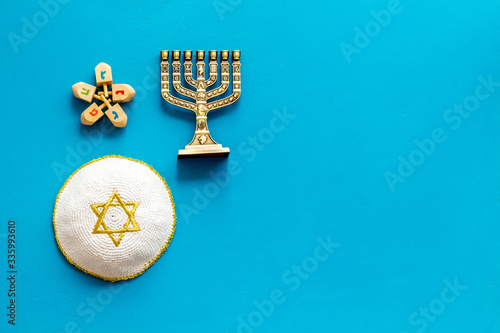 Jewish Kippah Yarmulkes hats with menorah on blue wooden table. Top view  copy space