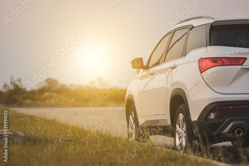 Travel white car parked on road sunset background