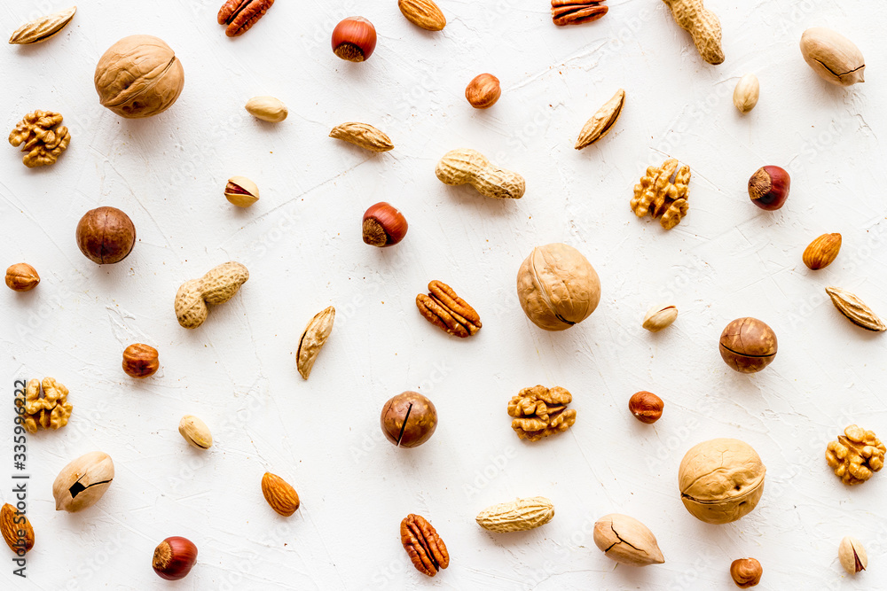 Nuts background - with almond, macadamia, walnut - on white table top-down Nuts background - with almond, macadamia, walnut - on white table top-down