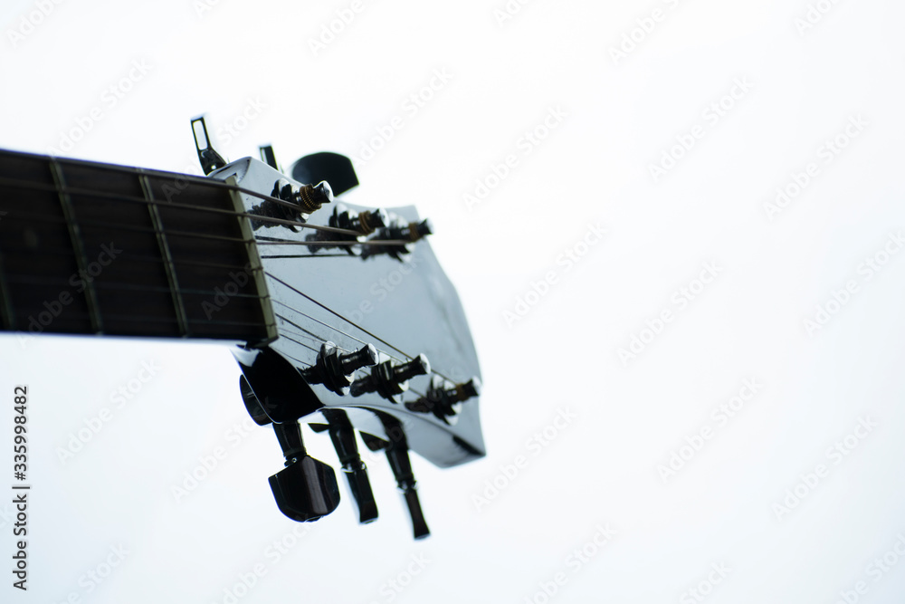 Macro elements of an acoustic guitar on a light background in monochrome.