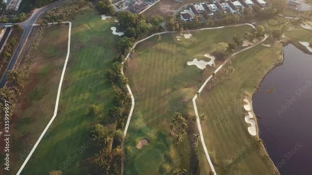 Aerial view of a golf course with a lake at sunrise Aerial view of a golf course with a lake at sunrise