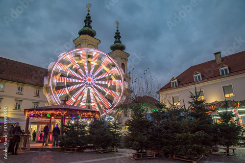 Ferris wheel and Christmas trees in front of Mariahilfer Church, Graz, Austria