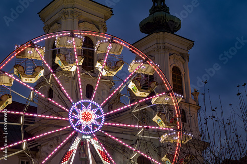 Ferris wheel in front of Mariahilfer Church spire, Graz, Austria