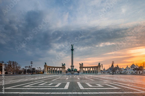 Budapest, Hungary - No people and tourists on the totally empty Heroes' Square on a morning day during 2020 Coronavirus disease quarantine with a beautiful sunrise at background