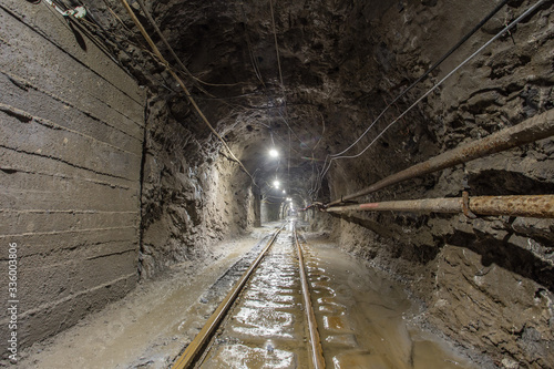 Underground gold mine tunnel with rails and light