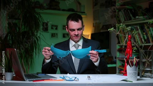 A man examines a female bra at the table. Closed flirt. A kind of courtship, indicating a certain opportunity or expectation of a relationship.