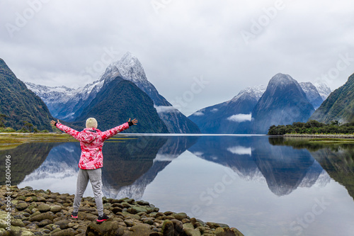 Young Asian traveler celebrating success at Milford Sound, Fiordland National Park, South Island, New Zealand © Worawat