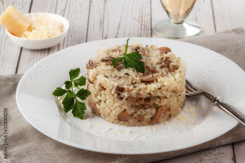 Wild mushroom risotto with parsley and parmesan on a white wooden background