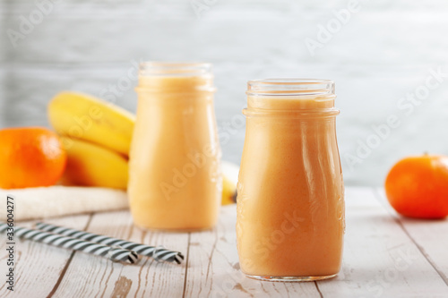 Tangerine and banana smoothie on wooden table