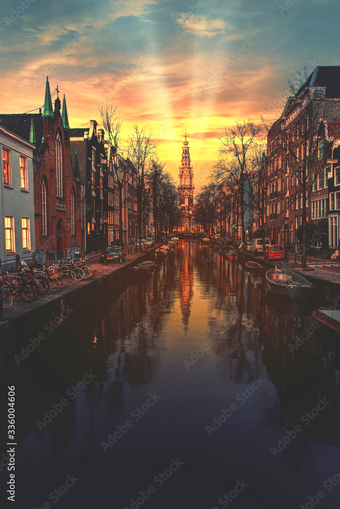 Warm sunset on the canal of Amsterdam reflected on the calm water, Netherlands