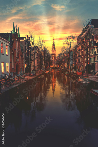 Warm sunset on the canal of Amsterdam reflected on the calm water, Netherlands