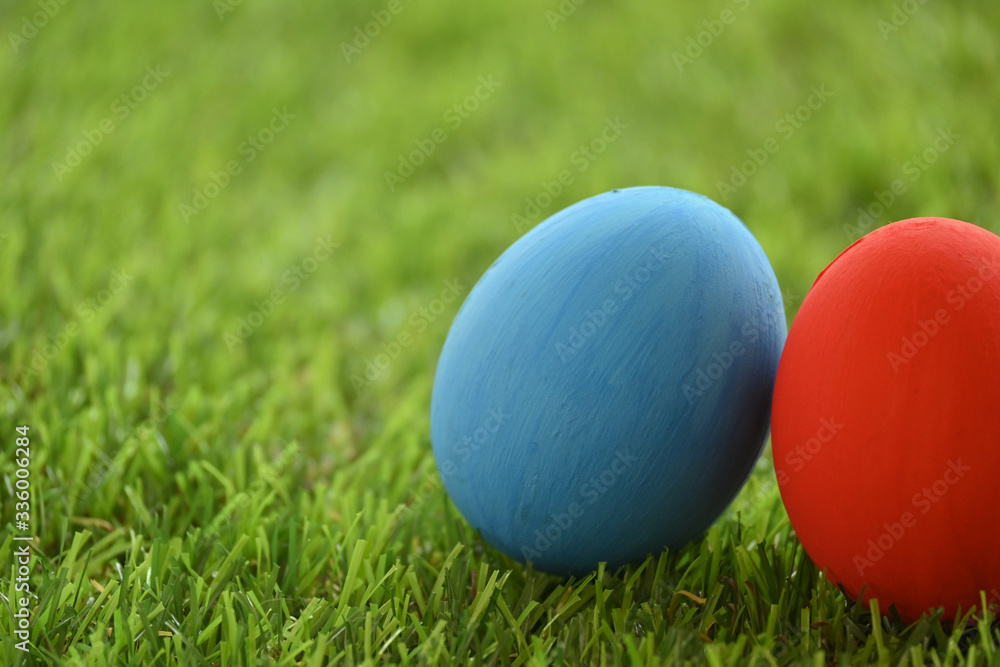 red and blue easter egg on lawn green grass artificial, concept image of morning in springtime