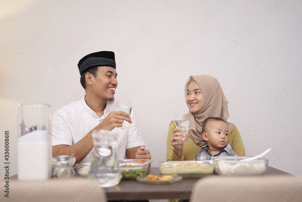 asian muslim family drink a glass of water for breaking the fast in the evening asian muslim family drink a glass of water for breaking the fast in the evening
