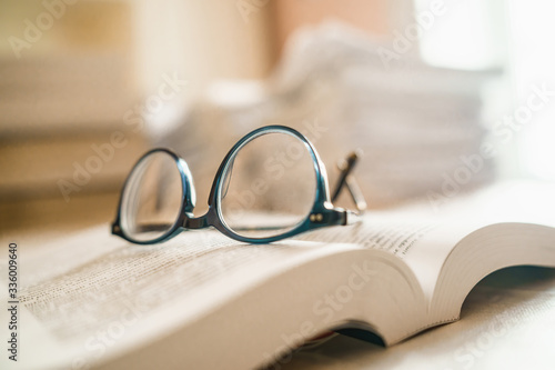 Eyeglasses on a book. Reader's or Student's tired in the calssroom concept. © Lomb