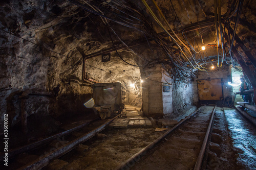 Underground gold mine tunnel with light and rails