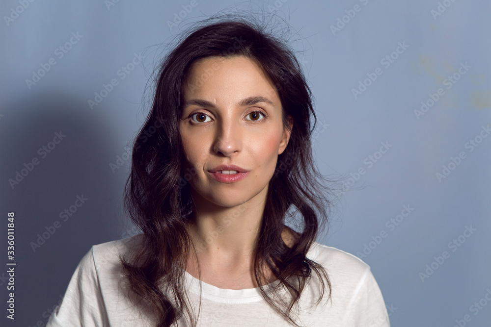 Fototapeta premium portrait of a brunette girl on a blue background