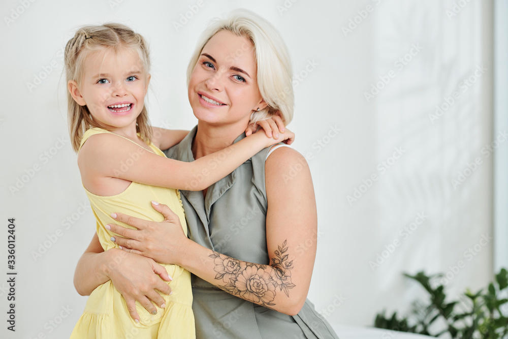 Portrait of happy smiling beautiful woman hugging her little daughter Portrait of happy smiling beautiful woman hugging her little daughter