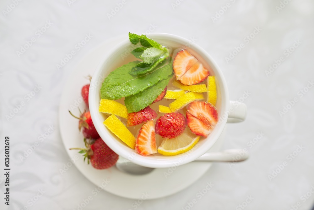 Strawberry tea with mint lemon berries on table close-up Strawberry tea with mint lemon berries on table close-up