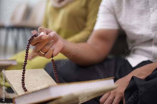 close up of hand holding praying beads counting and worship god