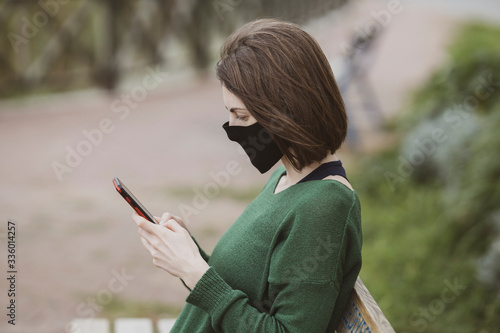 a woman talking on the phone with coronavirus mask