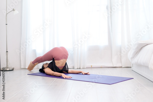 Young woman do yoga in a bed room