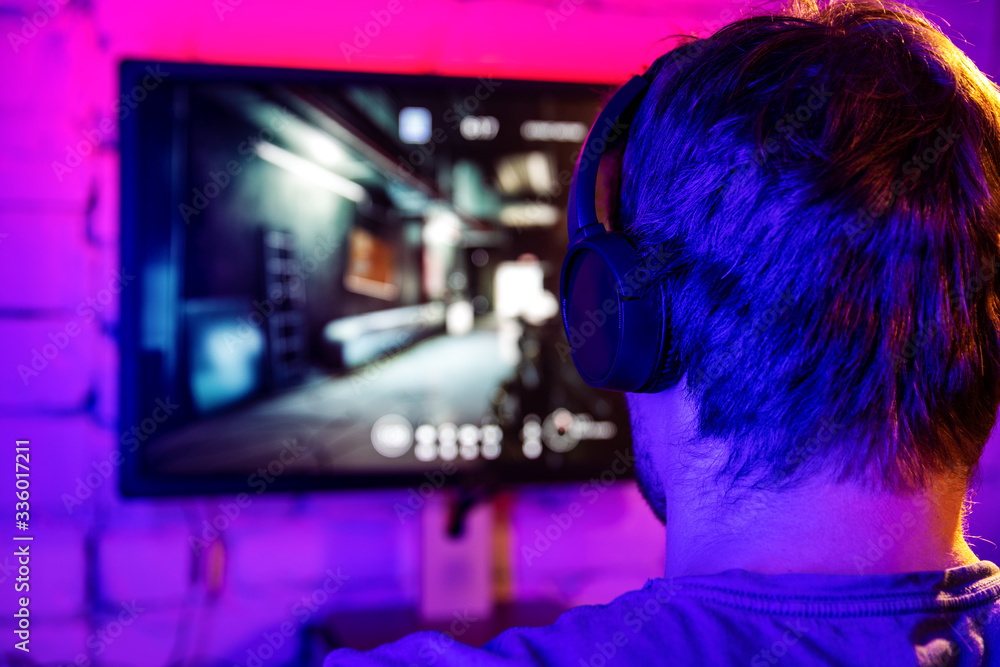 esports, gaming on pc - man playing online multiplayer shooter game. back view esports, gaming on pc - man playing online multiplayer shooter game. back view