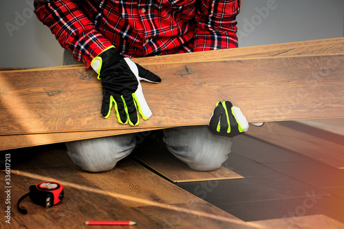 Work when installing a laminate floor. The man holds in the hands of parts of the floor. photo