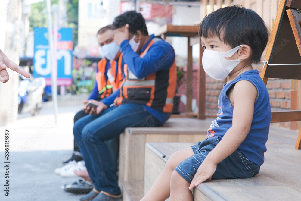 Little boy wear white mask protect Pm2.5 amd covid 19 sitting in cafe