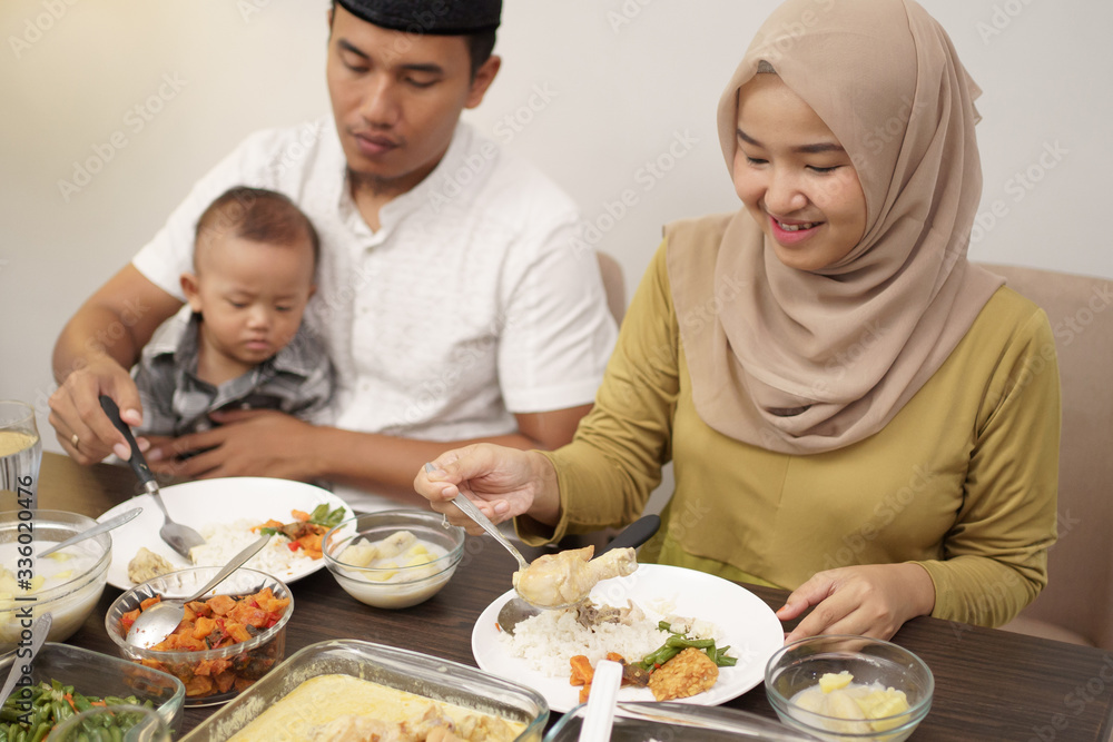 muslim family with toddler breakfasting during ramadan kareem at home together