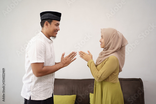 man and woman shake hand muslim touching apologizing on eid mubarak photo